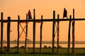 Silhouetted people on U Bein Bridge at sunset, Amarapura, Myanmar Royalty Free Stock Photo