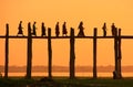 Silhouetted people on U Bein Bridge at sunset, Amarapura, Myanmar