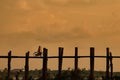 Silhouetted person with a bike on U Bein Bridge