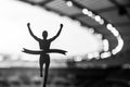 Silhouetted Runner Seizes Victory at Modern Athletics Stadium. An Inspiring Track and Field Competition Moment. Black and White Royalty Free Stock Photo