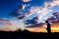 Silhouetted shot of a boy fishing on pier at sunset Royalty Free Stock Photo