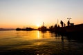 Silhouetted shot of a people fishing on pier at sunset Royalty Free Stock Photo