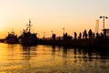 Silhouetted shot of a people fishing on pier at sunset Royalty Free Stock Photo