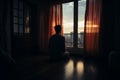 Silhouetted solitude man alone, staring at closed curtains in bedroom