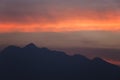 Silhouetted sunset sky with the mountains.beautiful orange clouds after sunset for background