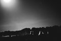 Silhouetted, unrecognizable people camping under full moon