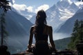 Silhouetted woman gazing at breathtaking mountain ranges, sitting amid serene nature.