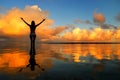 Silhouetted woman standing in a water at sunset on Taveuni Island, Fij