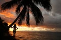 Silhouetted young woman by the palm tree on a beach, Vanua Levu Royalty Free Stock Photo