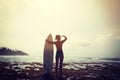 Silhouetted young woman surfer girl with white surfboard on a beach at sunrise Royalty Free Stock Photo