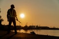 Silhouettes of asian man engineer holding wrenches and standing on shipyard and background is oil storage silo Royalty Free Stock Photo