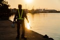 Silhouettes of asian man engineer holding wrenches and standing on shipyard and background is oil storage silo Royalty Free Stock Photo