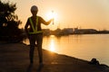 Silhouettes of asian woman engineer holding wrenches and standing on shipyard and background is oil storage silo. Concept of women Royalty Free Stock Photo