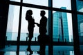 Silhouettes of backlit business people handshake Royalty Free Stock Photo