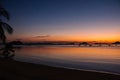 Silhouettes of boats and palm tree in tropical harbor in evening. Sunset in lagoon in Philippines, Palawan. Sunset on beach.