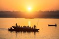 Silhouettes of Boats with pilgrims during amazing sunset on the Holy Ganges river, Varanasi.