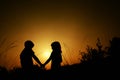 Silhouettes of a boy and a girl holding hands Royalty Free Stock Photo