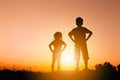 Silhouettes of boy and girl playing at sunset evening sky background Royalty Free Stock Photo