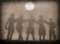 Silhouettes of boys and girls hugging on the beach on sunny summer day