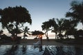 Silhouettes of the bride and groom at sunset. The reflection in the pool. Royalty Free Stock Photo