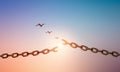 Silhouettes of broken chain and birds flying in sunrise sky background. Royalty Free Stock Photo