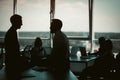 Silhouettes of business people have discussion in office interior with huge windows. Teamwork concept. Tinted image Royalty Free Stock Photo