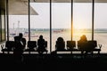 Silhouettes of business people traveling on airport; waiting at the plane boarding gates Royalty Free Stock Photo