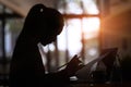 Silhouettes of businesswoman reading some paperwork while sitting in modern office.