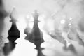 Silhouettes of chess pieces in the smoke of war. Black and white image. Abstraction of the battle strategy.