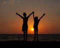 silhouettes of children against the background of a sea sunset