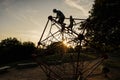 Silhouettes of children play in rope polyhedron climb at playground outdoor Royalty Free Stock Photo