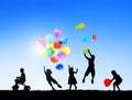 Silhouettes of Children Playing Balloons Outdoors Royalty Free Stock Photo