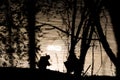 Silhouettes of children sitting by the water with ripples