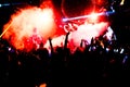 Silhouettes of concert crowd in front of bright stage lights with confetti