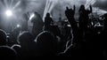 Silhouettes of concert crowd in front of bright stage lights. the pop rock concert in front of the stage. Hands with gesture Horns Royalty Free Stock Photo