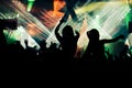 Silhouettes of concert crowd in front of bright stage lights