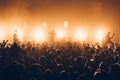 Silhouettes of concert crowd in front of bright stage lights. A sold out crowd on rock concert. Crowd of fans at music festive. Pa Royalty Free Stock Photo