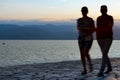 Silhouettes of couple blurred in motion as they walk with sun behind Royalty Free Stock Photo