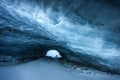 Silhouettes of a couple of hikers at the entrance of an ice cave in Zermatt, Valais Switzerland