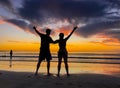 Silhouettes of couple in love at beach sunset celebrating freedom and love Royalty Free Stock Photo