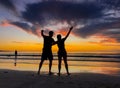 Silhouettes of couple in love at beach sunset celebrating freedom and love Royalty Free Stock Photo