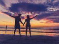 Silhouettes of couple in love at beach sunset celebrating freedom and love Royalty Free Stock Photo