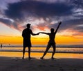 Silhouettes of couple in love at beach sunset celebrating freedom and love Royalty Free Stock Photo