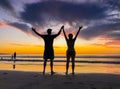 Silhouettes of couple in love at beach sunset celebrating freedom and love Royalty Free Stock Photo