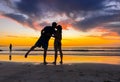 Silhouettes of couple in love kissing at beach sunset celebrating freedom and love Royalty Free Stock Photo