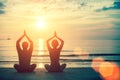 Silhouettes couple man and woman practicing yoga at sunset