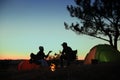 Silhouettes of couple near bonfire in evening. Camping season