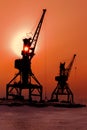 Silhouettes cranes freight ship on shore of Lake Baikal in winter at sunset.