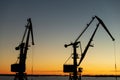 Silhouettes of cranes in the port in the evening at sunset Royalty Free Stock Photo