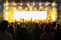 Silhouettes of crowd, group of people, cheering in live music concert in front of colorful stage lights